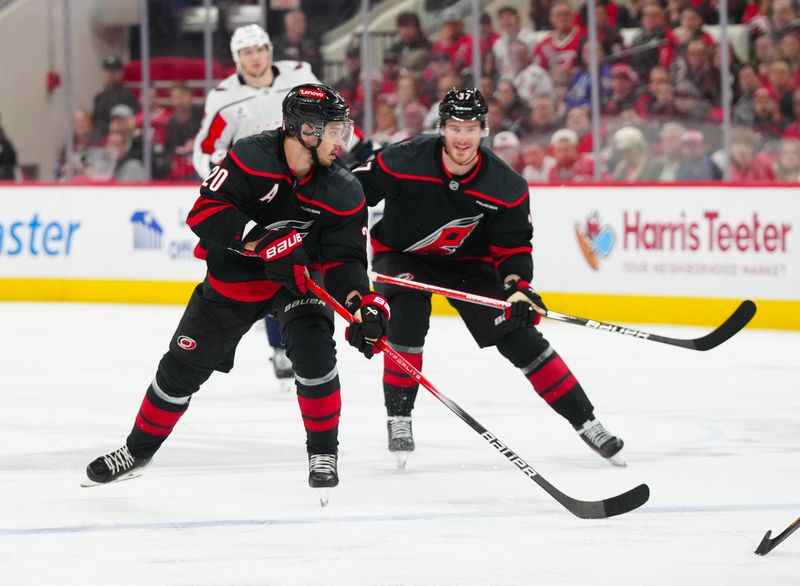 May 12, 2025; Raleigh, North Carolina, USA; Carolina Hurricanes center Sebastian Aho (20) carries the puck with Carolina Hurricanes right wing Andrei Svechnikov (37) against the Washington Capitals during the third period in game four of the second round of the 2025 Stanley Cup Playoffs at Lenovo Center. Mandatory Credit: James Guillory-Imagn Images