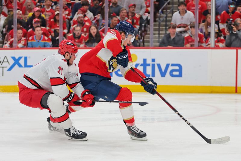 May 26, 2025; Sunrise, Florida, USA; Carolina Hurricanes defenseman Alexander Nikishin (21) defends against Florida Panthers center Anton Lundell (15) during the third period in game four of the Eastern Conference Final of the 2025 Stanley Cup Playoffs at Amerant Bank Arena. Mandatory Credit: Sam Navarro-Imagn Images