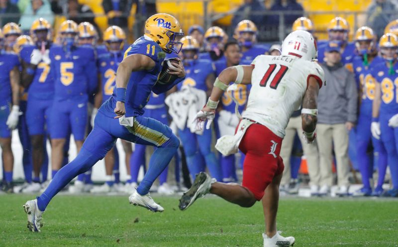 Oct 14, 2023; Pittsburgh, Pennsylvania, USA; Pittsburgh Panthers quarterback Christian Veilleux (left) runs with the ball as Louisville Cardinals defensive back Cam'Ron Kelly (right) chases during the third quarter against at Acrisure Stadium. Pittsburgh won 38-21.Mandatory Credit: Charles LeClaire-USA TODAY Sports