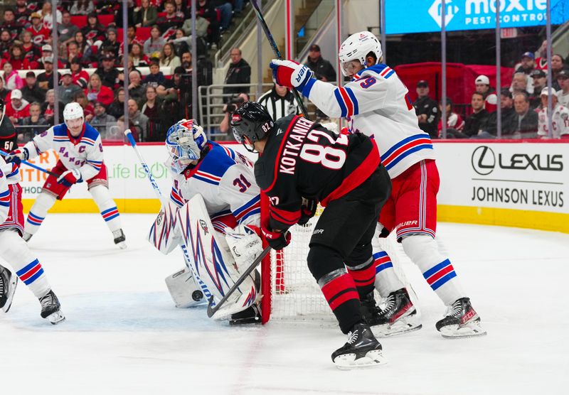 Nov 27, 2024; Raleigh, North Carolina, USA;  Carolina Hurricanes center Jesperi Kotkaniemi (82) scores a goal past New York Rangers goaltender Igor Shesterkin (31) and defenseman K'Andre Miller (79) during the third period at Lenovo Center. Mandatory Credit: James Guillory-Imagn Images