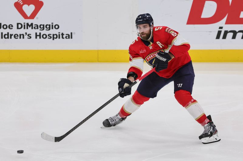 Jan 19, 2024; Sunrise, Florida, USA; Florida Panthers defenseman Aaron Ekblad (5) moves the puck against the Minnesota Wild during the third period at Amerant Bank Arena. Mandatory Credit: Sam Navarro-USA TODAY Sports