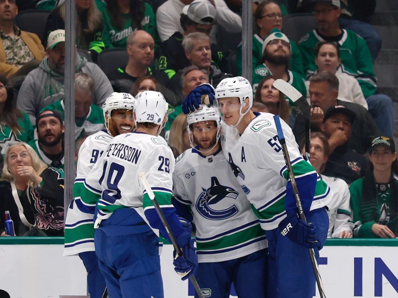 Oct 16, 2025; Dallas, Texas, USA; Vancouver Canucks center Max Sasson (63) celebrates with teammates after scoring a goal against the Dallas Stars during the second period at American Airlines Center. Mandatory Credit: Chris Jones-Imagn Images