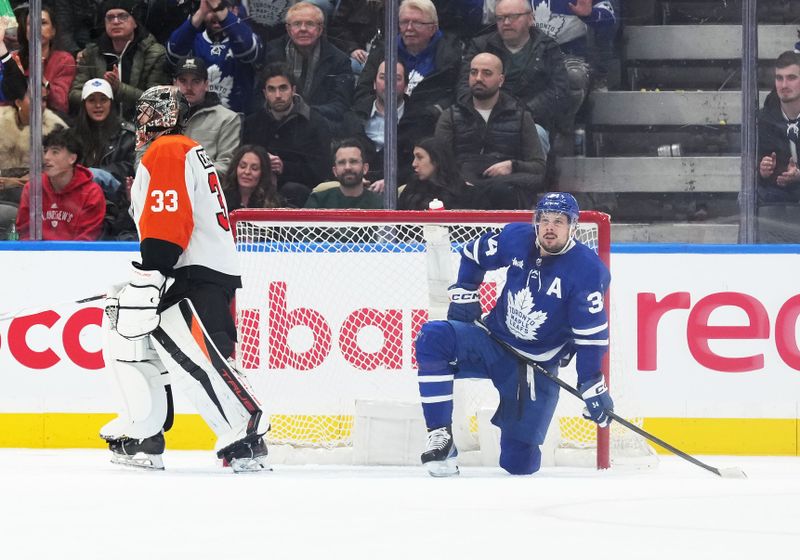 Feb 15, 2024; Toronto, Ontario, CAN; Toronto Maple Leafs center Auston Matthews (34) takes a break in front of the net of Philadelphia Flyers goaltender Samuel Ersson (33) during the second period at Scotiabank Arena. Mandatory Credit: Nick Turchiaro-USA TODAY Sports