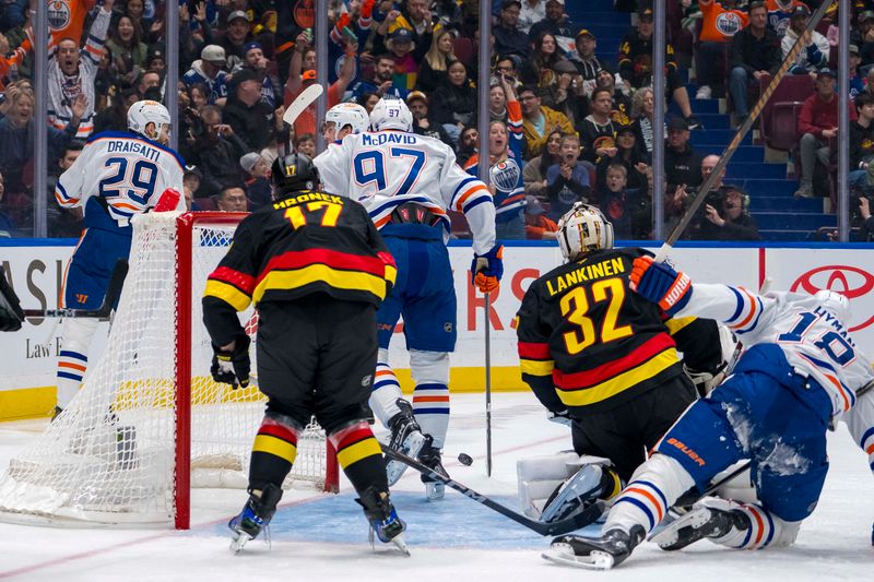 Nov 9, 2024; Vancouver, British Columbia, CAN; Vancouver Canucks defenseman Filip Hronek (17) and goalie Kevin Lankinen (32) watch as Edmonton Oilers forward Leon Draisaitl (29) and forward Connor McDavid (97) and forward Ryan Nugent-Hopkins (93) celebrate Draisaitl’s goal during the first period at Rogers Arena. Mandatory Credit: Bob Frid-Imagn Images