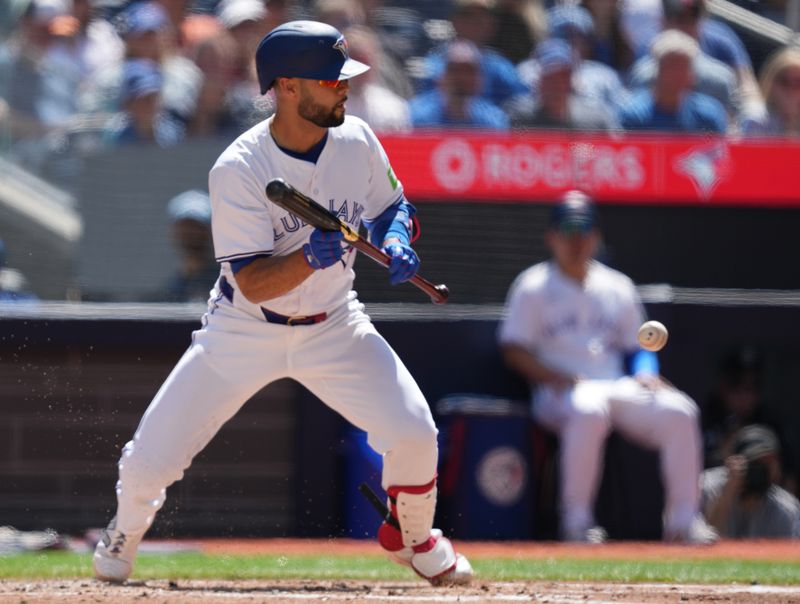 Jun 15, 2024; Toronto, Ontario, CAN; Toronto Blue Jays shortstop Isiah Kiner-Falefa (7) lays down a sacrifice bunt advancing the base runners against the Cleveland Guardians during the second inning at Rogers Centre. Mandatory Credit: Nick Turchiaro-USA TODAY Sports