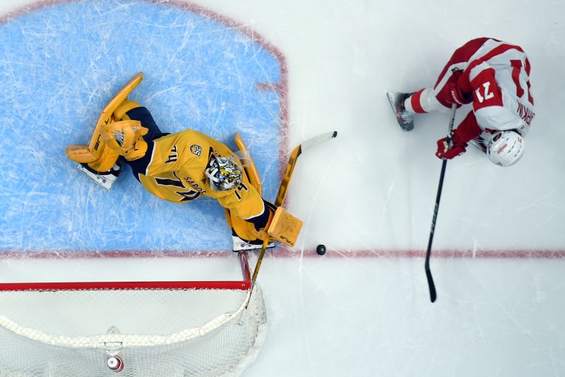 Mar 23, 2024; Nashville, Tennessee, USA; Nashville Predators goaltender Juuse Saros (74) makes a save on a shot by Detroit Red Wings center Dylan Larkin (71) during the first period at Bridgestone Arena. Mandatory Credit: Christopher Hanewinckel-USA TODAY Sports