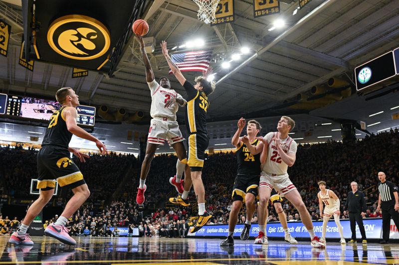 Feb 17, 2024; Iowa City, Iowa, USA; Wisconsin Badgers guard AJ Storr (2) goes to the basket as Iowa Hawkeyes forward Owen Freeman (32) and forward Pryce Sandfort (24) and forward Payton Sandfort (20) defend as forward Steven Crowl (22) looks on during the first half at Carver-Hawkeye Arena. Mandatory Credit: Jeffrey Becker-USA TODAY Sports