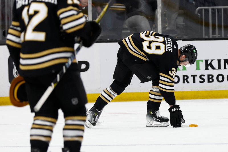 Feb 29, 2024; Boston, Massachusetts, USA; Boston Bruins center Morgan Geekie (39) picks up a hat off the ice after scoring his third goal of the game during the seond period against the Vegas Golden Knights at TD Garden. Mandatory Credit: Winslow Townson-USA TODAY Sports