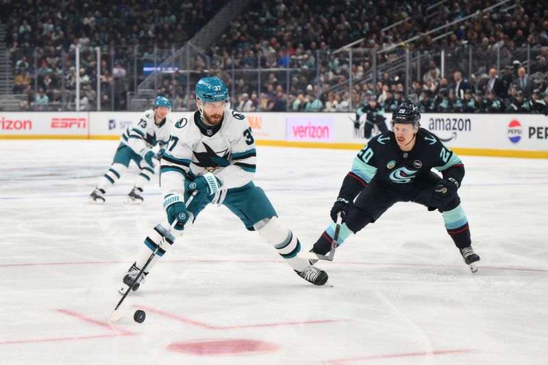 Jan 30, 2025; Seattle, Washington, USA; San Jose Sharks defenseman Timothy Liljegren (37) plays the puck while defended by Seattle Kraken right wing Eeli Tolvanen (20) during the first period at Climate Pledge Arena. Mandatory Credit: Steven Bisig-Imagn Images