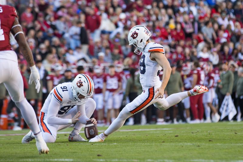 oNov 11, 2023; Fayetteville, Arkansas, USA;  Auburn Tigers place kicker Alex McPherson (38) kicks an extra point from holder Oscar Chapman (91) during the first quarter against the Arkansas Razorbacks at Donald W. Reynolds Razorback Stadium. Auburn won 48-10. Mandatory Credit: Brett Rojo-USA TODAY Sports