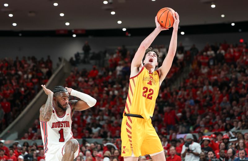 Feb 19, 2024; Houston, Texas, USA; Iowa State Cyclones forward Milan Momcilovic (22) shoots the ball as Houston Cougars guard Jamal Shead (1) reacts during the first half at Fertitta Center. Mandatory Credit: Troy Taormina-USA TODAY Sports