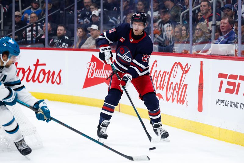 Oct 18, 2024; Winnipeg, Manitoba, CAN;  Winnipeg Jets forward Nikolaj Ehlers (27) makes a pass by San Jose Sharks defenseman Mario Ferraro (38) during the second period at Canada Life Centre. Mandatory Credit: Terrence Lee-Imagn Images