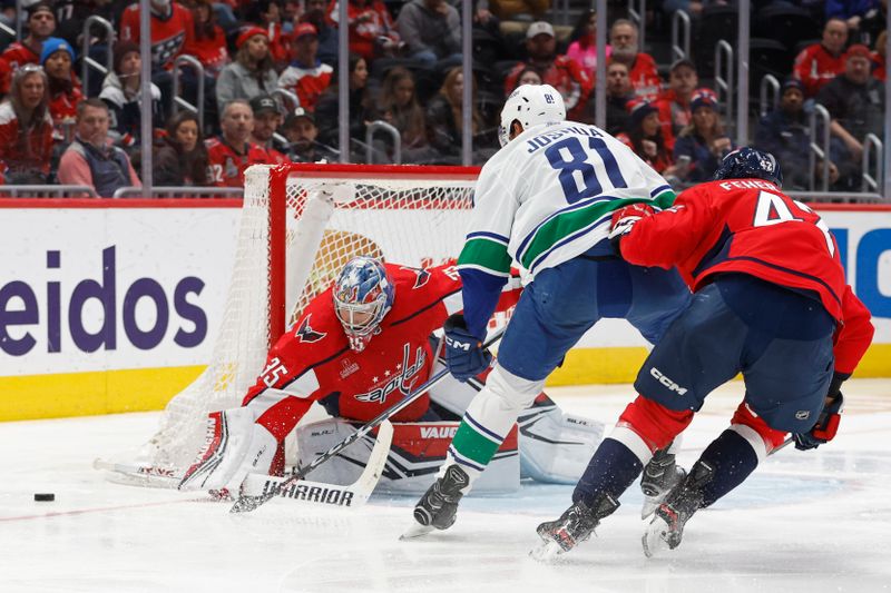 Feb 11, 2024; Washington, District of Columbia, USA; Washington Capitals goaltender Darcy Kuemper (35) makes a save on Vancouver Canucks center Dakota Joshua (81) as Capitals defenseman Martin Fehervary (42) defends in the second period at Capital One Arena. Mandatory Credit: Geoff Burke-USA TODAY Sports