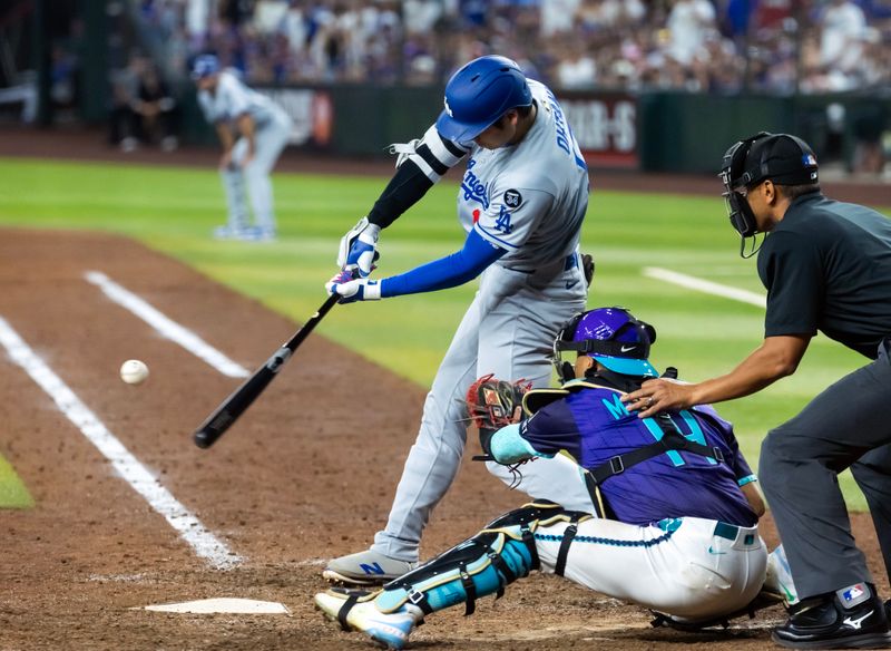 May 9, 2025; Phoenix, Arizona, USA; Los Angeles Dodgers designated hitter Shohei Ohtani hits a three run home run in the ninth inning against the Arizona Diamondbacks at Chase Field. Mandatory Credit: Mark J. Rebilas-Imagn Images