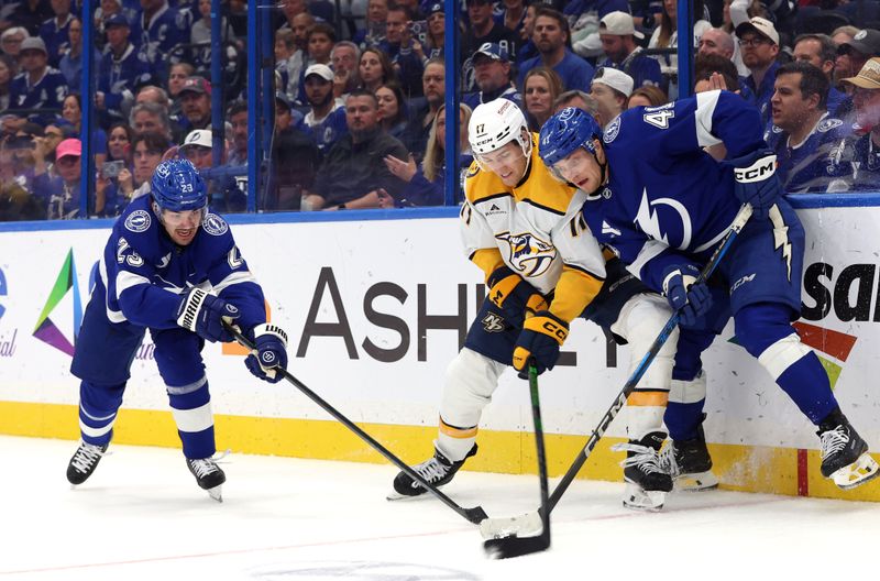 Oct 28, 2024; Tampa, Florida, USA; Tampa Bay Lightning center Michael Eyssimont (23), right wing Mitchell Chaffee (41), and Nashville Predators center Mark Jankowski (17) fight to control the puck during the third period at Amalie Arena. Mandatory Credit: Kim Klement Neitzel-Imagn Images