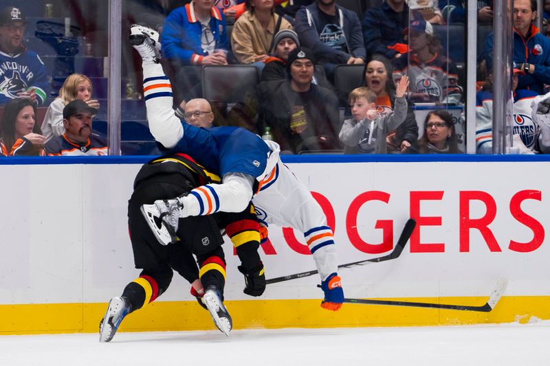 Nov 6, 2023; Vancouver, British Columbia, CAN; Edmonton Oilers forward Warren Foegele (37) hits Vancouver Canucks forward Elias Pettersson (40) in the third period at Rogers Arena. Vancouver won 6-2. Mandatory Credit: Bob Frid-USA TODAY Sports