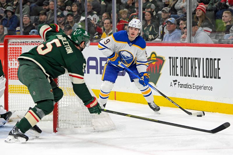Mar 22, 2025; Saint Paul, Minnesota, USA;  Buffalo Sabres forward Zach Benson (9) looks to pass as Minnesota Wild defenseman Jacob Middleton (5) defends during the first period at Xcel Energy Center. Mandatory Credit: Nick Wosika-Imagn Images