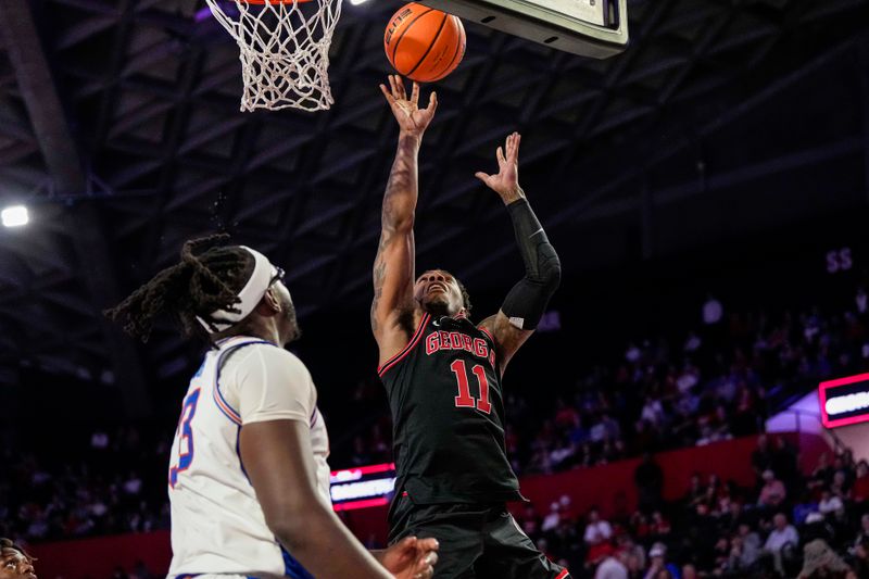 Feb 28, 2023; Athens, Georgia, USA; Georgia Bulldogs guard Justin Hill (11) shoots over Florida Gators center Jason Jitoboh (33) during the second half at Stegeman Coliseum. Mandatory Credit: Dale Zanine-USA TODAY Sports