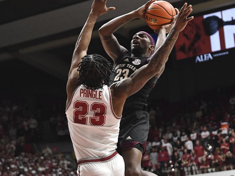 Feb 17, 2024; Tuscaloosa, Alabama, USA; Texas A&M Aggies guard Tyrece Radford (23) drives against Alabama Crimson Tide forward Nick Pringle (23) during the first half at Coleman Coliseum. Mandatory Credit: Gary Cosby Jr.-USA TODAY Sports