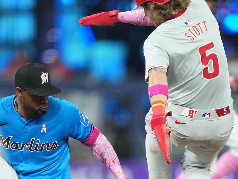 May 12, 2024; Miami, Florida, USA;  Philadelphia Phillies second baseman Bryson Stott (5) steals second base as Miami Marlins shortstop Vidal Bruján (17) drops the ball in the seventh inning at loanDepot Park. Mandatory Credit: Jim Rassol-USA TODAY Sports