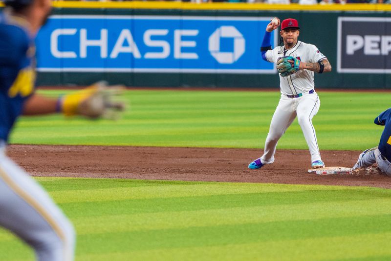 Sep 15, 2024; Phoenix, Arizona, USA; Arizona Diamondbacks infielder Ketel Marte (4) tags second base and turns to throw to first base during the third inning of a game against the Milwaukee Brewers at Chase Field. Mandatory Credit: Allan Henry-USA TODAY Sports