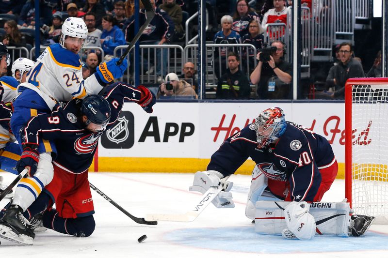 Oct 17, 2024; Columbus, Ohio, USA; Buffalo Sabres center Dylan Cozens (24) reaches over Columbus Blue Jackets defenseman Ivan Provorov (9) for the loose puck as Columbus goalie Daniil Tarasov (40) sticks it aside during the third period at Nationwide Arena. Mandatory Credit: Russell LaBounty-Imagn Images