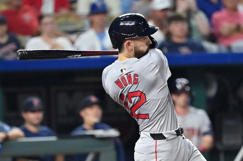 Aug 5, 2024; Kansas City, Missouri, USA;  Boston Red Sox catcher Connor Wong (12) doubles in a run in the seventh inning against the Kansas City Royals at Kauffman Stadium. Mandatory Credit: Peter Aiken-USA TODAY Sports