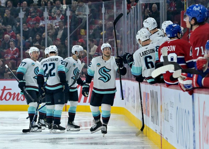 Oct 29, 2024; Montreal, Quebec, CAN; Seattle Kraken defenseman Brandon Montour (62) celebrates with teammates after scoring a goal against the Montreal Canadiens during the second period at the Bell Centre. Mandatory Credit: Eric Bolte-Imagn Images