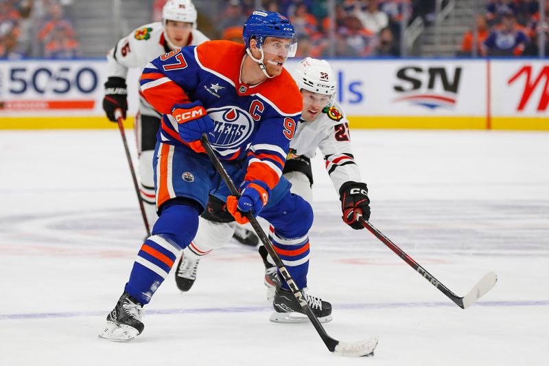 Oct 12, 2024; Edmonton, Alberta, CAN; Edmonton Oilers forward Connor McDavid (97) looks to make a pass in front of Chicago Blackhawks forward Philipp Kurashev (23) during the third period at Rogers Place. Mandatory Credit: Perry Nelson-Imagn Images