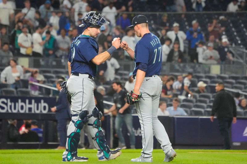 Jun 22, 2023; Bronx, New York, USA;  Seattle Mariners catcher Cal Raleigh (29) and pitcher Chris Flexen (77) bump fists to celebrate the victory against the New York Yankees at Yankee Stadium. Mandatory Credit: Gregory Fisher-USA TODAY Sports