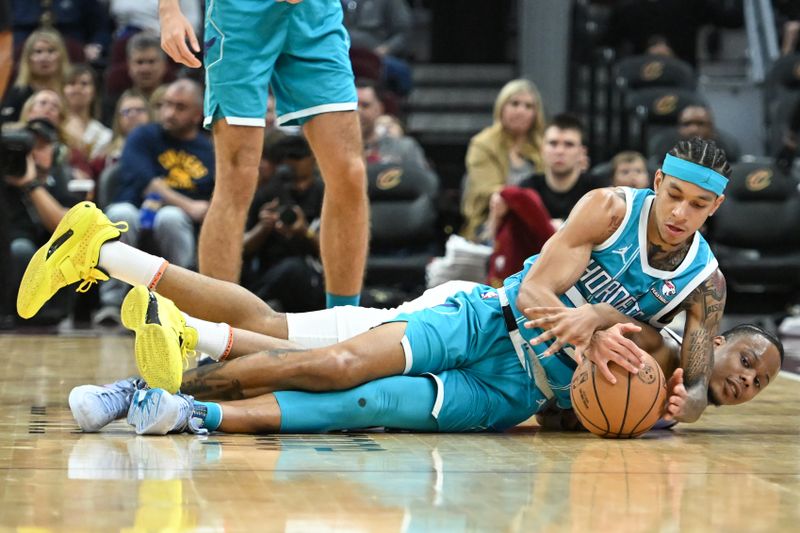 CLEVELAND, OHIO - APRIL 14: Tre Mann #23 of the Charlotte Hornets fights for the loose ball against Isaac Okoro #35 of the Cleveland Cavaliers during the first half at Rocket Mortgage Fieldhouse on April 14, 2024 in Cleveland, Ohio. NOTE TO USER: User expressly acknowledges and agrees that, by downloading and or using this photograph, User is consenting to the terms and conditions of the Getty Images License Agreement. (Photo by Nick Cammett/Getty Images)