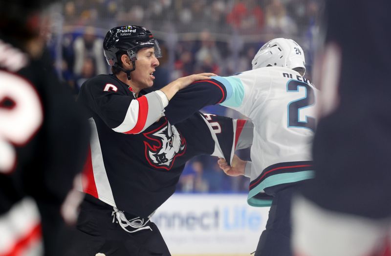 Mar 28, 2026; Buffalo, New York, USA;  Buffalo Sabres defenseman Logan Stanley (64) and Seattle Kraken defenseman Jamie Oleksiak (24) fight during the second period at KeyBank Center. Mandatory Credit: Timothy T. Ludwig-Imagn Images