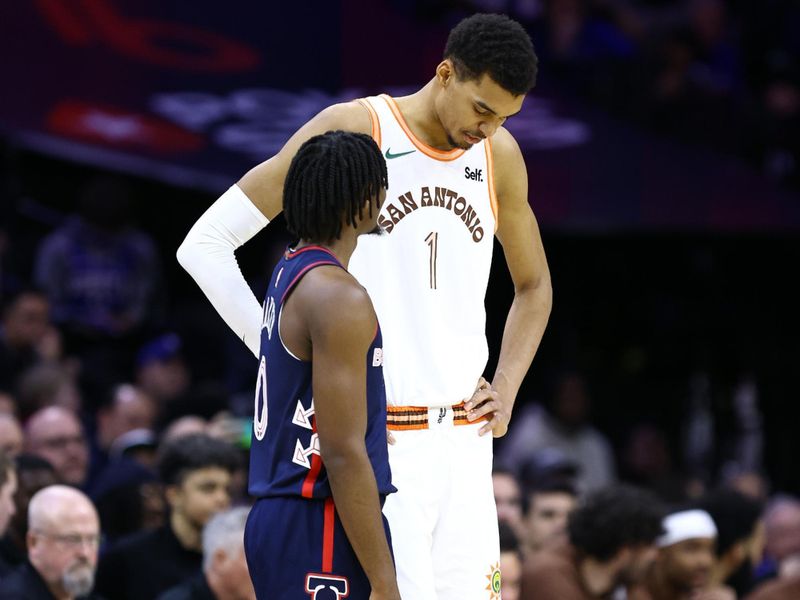 PHILADELPHIA, PENNSYLVANIA - JANUARY 22: Tyrese Maxey #0 of the Philadelphia 76ers and Victor Wembanyama #1 of the San Antonio Spurs speak during the third quarter at the Wells Fargo Center on January 22, 2024 in Philadelphia, Pennsylvania. NOTE TO USER: User expressly acknowledges and agrees that, by downloading and or using this photograph, User is consenting to the terms and conditions of the Getty Images License Agreement. (Photo by Tim Nwachukwu/Getty Images)