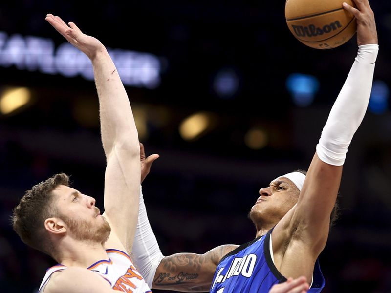 ORLANDO, FLORIDA - MARCH 23: Paolo Banchero #5 of the Orlando Magic drives to the net as Isaiah Hartenstein #55 of the New York Knicks defends during the third quarter at Amway Center on March 23, 2023 in Orlando, Florida. NOTE TO USER: User expressly acknowledges and agrees that, by downloading and or using this photograph, User is consenting to the terms and conditions of the Getty Images License Agreement. (Photo by Douglas P. DeFelice/Getty Images)