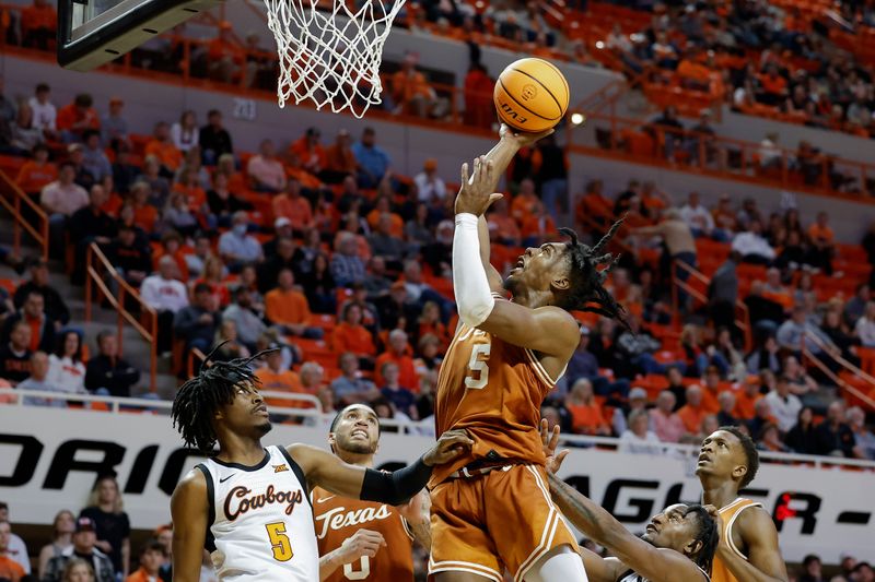 Jan 7, 2023; Stillwater, Oklahoma, USA; Texas Longhorns guard Marcus Carr (5) shoots over Oklahoma State Cowboys guard Caleb Asberry (5) during the second half at Gallagher-Iba Arena. Mandatory Credit: Alonzo Adams-USA TODAY Sports