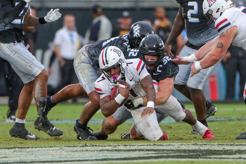 Nov 2, 2024; Orlando, Florida, USA; Arizona Wildcats running back Quali Conley (7) is tackled by UCF Knights linebacker Ethan Barr (32) during the second half at FBC Mortgage Stadium. Mandatory Credit: Mike Watters-Imagn Images