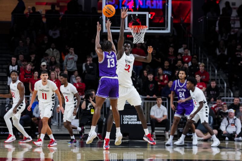 Dec 1, 2025; Cincinnati, Ohio, USA;  Tarleton State Texans guard Kade Douglas (13) attempts a 3-point shot against Cincinnati Bearcats center Moustapha Thiam (52) in the first half at Fifth Third Arena. Mandatory Credit: Aaron Doster-Imagn Images