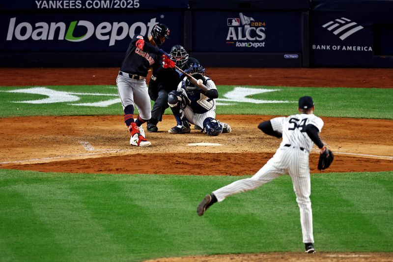 Oct 14, 2024; Bronx, New York, USA; Cleveland Guardians second base Andrés Giménez (0) hits a single during the eighth inning against the New York Yankees in game one of the ALCS for the 2024 MLB Playoffs at Yankee Stadium. Mandatory Credit: Vincent Carchietta-Imagn Images