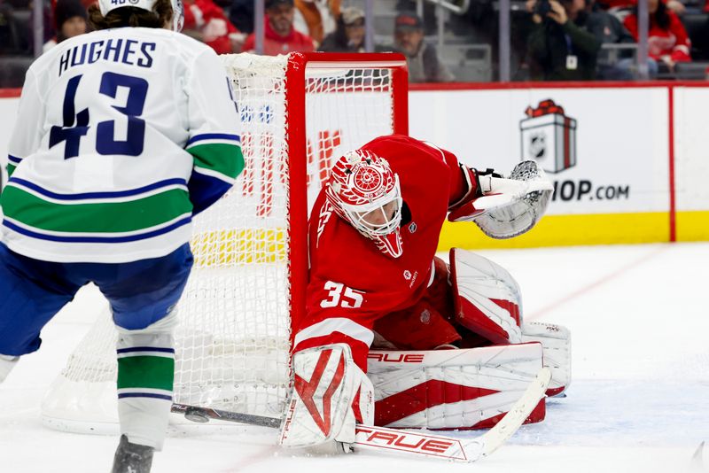 Dec 1, 2024; Detroit, Michigan, USA;  Detroit Red Wings goaltender Ville Husso (35) makes a save on Vancouver Canucks defenseman Quinn Hughes (43) in the third period at Little Caesars Arena. Mandatory Credit: Rick Osentoski-Imagn Images