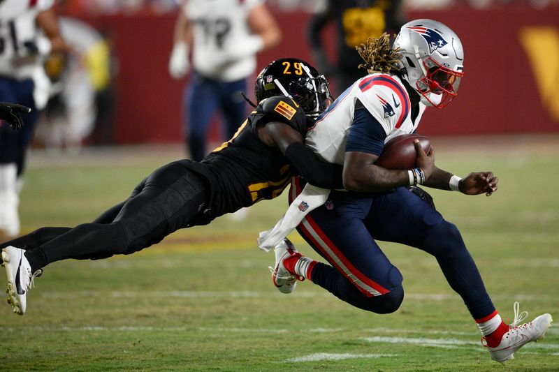 New England Patriots quarterback Joe Milton III, right, runs against Washington Commanders cornerback James Pierre during the second half of a preseason NFL football game, Sunday, Aug. 25, 2024, in Landover, Md. (AP Photo/Nick Wass)