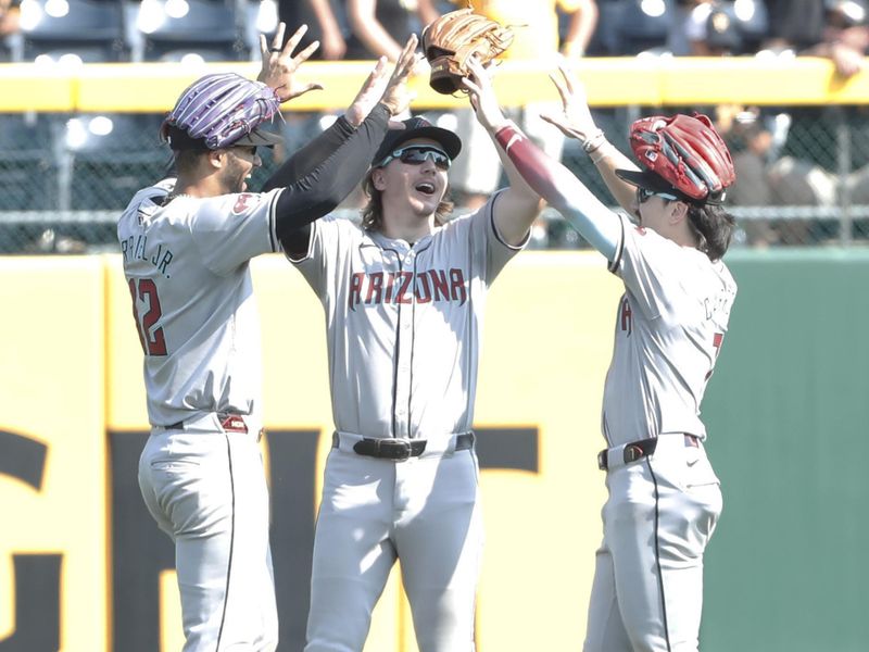 Aug 4, 2024; Pittsburgh, Pennsylvania, USA;  Arizona Diamondbacks left fielder Lourdes Gurriel Jr. (left) and center fielder Jake McCarthy (middle) and right fielder Corbin Carroll (right) celebrate in the outfield after defeating the Pittsburgh Pirates at PNC Park. Arizona won 6-5. Mandatory Credit: Charles LeClaire-USA TODAY Sports