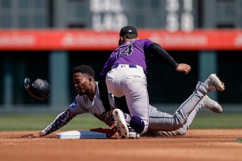Aug 29, 2024; Denver, Colorado, USA; Miami Marlins designated hitter Jesus Sanchez (12) safely steals second against Colorado Rockies shortstop Ezequiel Tovar (14) in the first inning at Coors Field. Mandatory Credit: Isaiah J. Downing-USA TODAY Sports