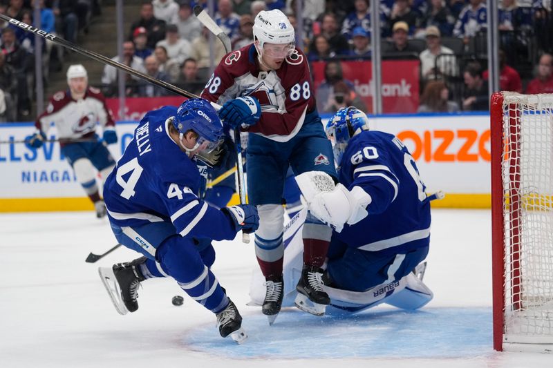 Mar 19, 2025; Toronto, Ontario, CAN; Colorado Avalanche forward Martin Necas (88) crashes into Toronto Maple Leafs goaltender Joseph Woll (60) and defenceman Morgan Rielly (44) during the second period at Scotiabank Arena. Mandatory Credit: John E. Sokolowski-Imagn Images