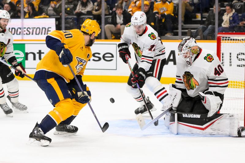 Jan 16, 2025; Nashville, Tennessee, USA;  Chicago Blackhawks goaltender Arvid Soderblom (40) blocks the shot of Nashville Predators center Ryan O'Reilly (90) during the third period at Bridgestone Arena. Mandatory Credit: Steve Roberts-Imagn Images