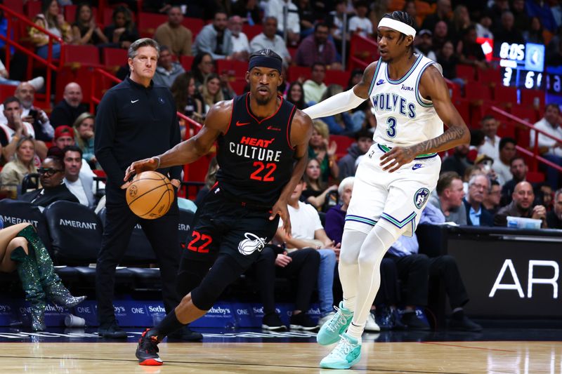 MIAMI, FLORIDA - DECEMBER 18: Jimmy Butler #22 of the Miami Heat drives against Jaden McDaniels #3 of the Minnesota Timberwolves during the third quarter of the game at Kaseya Center on December 18, 2023 in Miami, Florida. NOTE TO USER: User expressly acknowledges and agrees that, by downloading and or using this photograph, User is consenting to the terms and conditions of the Getty Images License Agreement. (Photo by Megan Briggs/Getty Images)