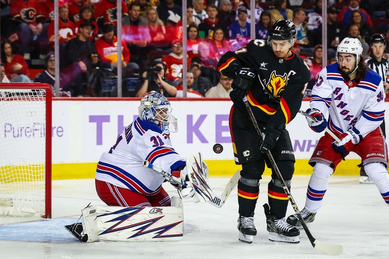 Nov 21, 2024; Calgary, Alberta, CAN; New York Rangers goaltender Igor Shesterkin (31) makes a save as Calgary Flames center Mikael Backlund (11) screens in front during the second period at Scotiabank Saddledome. Mandatory Credit: Sergei Belski-Imagn Images