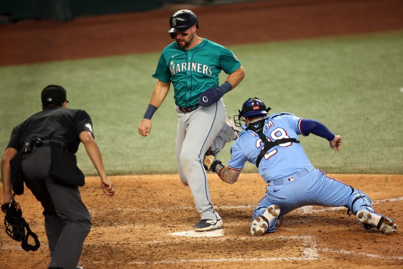 Jun 29, 2025; Arlington, Texas, USA; Texas Rangers catcher Jonah Heim (28) tags out Seattle Mariners designated hitter Cal Raleigh (29) during the tenth inning at Globe Life Field. Mandatory Credit: Tim Heitman-Imagn Images