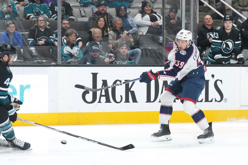 Feb 17, 2024; San Jose, California, USA; Columbus Blue Jackets right wing Yegor Chinakhov (59) shoots against San Jose Sharks defenseman Marc-Edouard Vlasic (far left) during the first period at SAP Center at San Jose. Mandatory Credit: Darren Yamashita-USA TODAY Sports