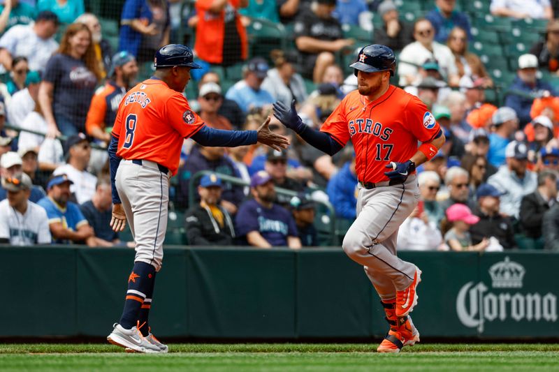 May 30, 2024; Seattle, Washington, USA; Houston Astros catcher Victor Caratini (17) high-fives third base coach Gary Pettis (8) after hitting a solo-home run against the Seattle Mariners during the fifth inning at T-Mobile Park. Mandatory Credit: Joe Nicholson-USA TODAY Sports