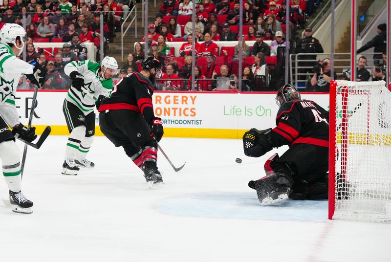 Nov 25, 2024; Raleigh, North Carolina, USA;  Dallas Stars center Matt Duchene (95) takes a shot against Carolina Hurricanes goaltender Spencer Martin (41) and  defenseman Brent Burns (8) during the second period at Lenovo Center. Mandatory Credit: James Guillory-Imagn Images